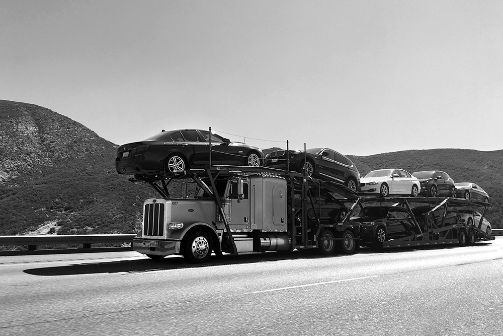 an auto transport carrier driving down the road in Albuquerque New Mexico