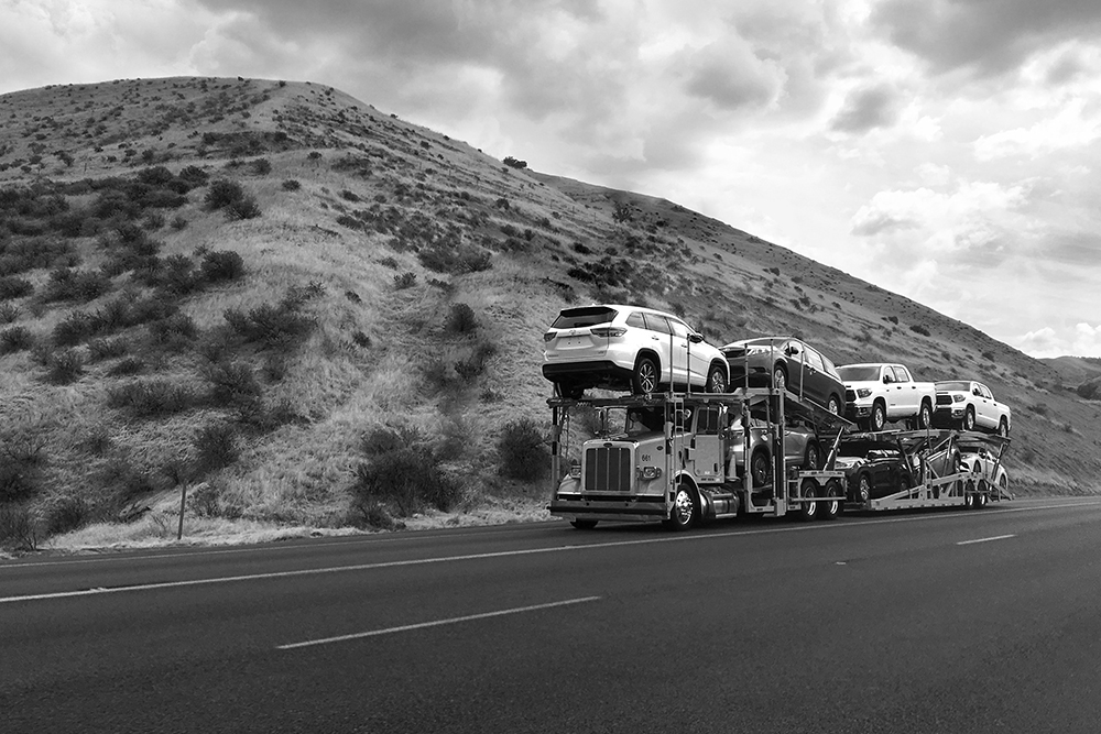 an auto transport carrier driving down the road in Albuquerque New Mexico